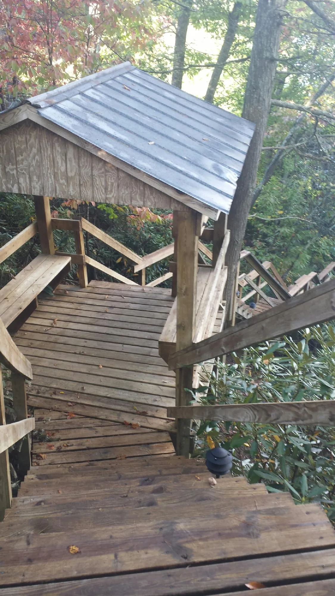 Metal roofed shelter over wooden steps on a wooded walkway — Skylight Repair & Installation work by our crew in North Canton