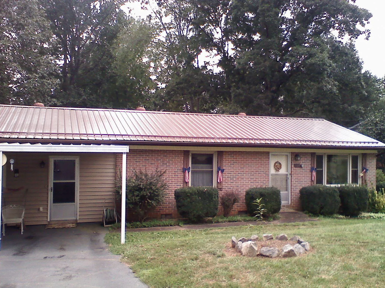 Bronze metal roof and carport on a brick ranch home — Roof Repair work by our crew in North Canton